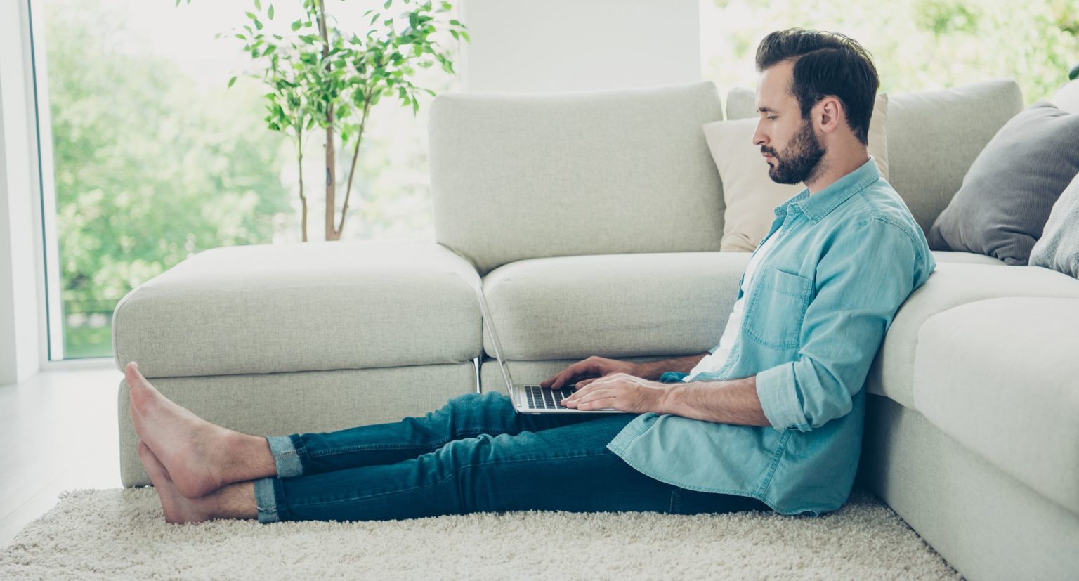 Man sitting on area rug in living room