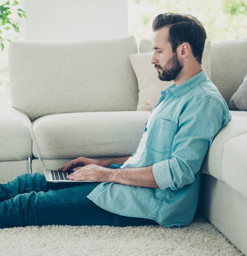 Man sitting on area rug in living room